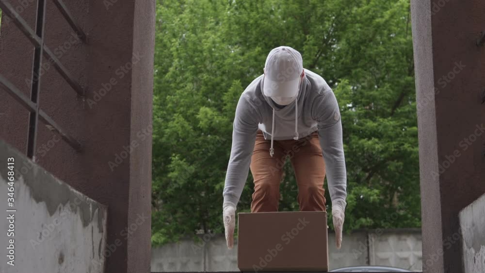 The courier delivers the package on the doorstep of the house. Food delivery during a pandemic, coronavirus. The courier delivers the package on the doorstep of the house. Food delivery during a pandemic, coronavirus.