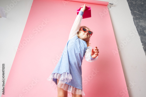 Little girl child in sunglasses with a pink redicle.