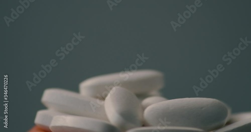 Macro shot of cluster of white vitamin supplements balancing and rotating on surface photo