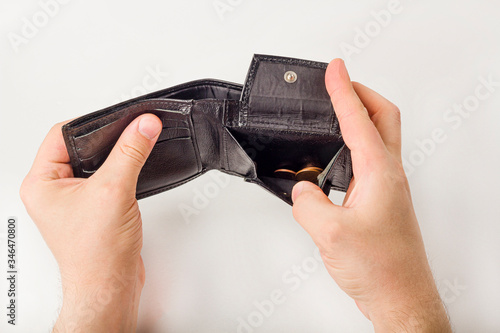 Male hand opening a wallet and count coins (money) on white background. World economic crisis. Financial problem jobless, bankruptcy concept. Copy space for text