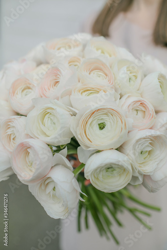 White peony roses bouquet in girl s hands by the Brick wall