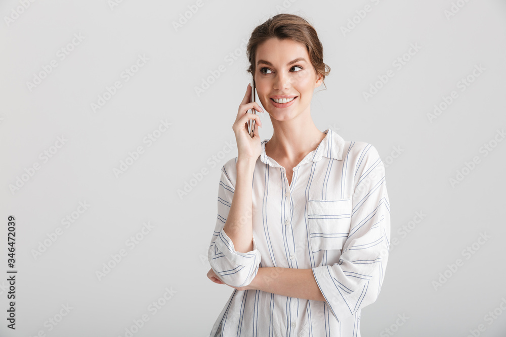 Image of joyful beautiful woman smiling and talking on mobile phone Image of joyful beautiful woman smiling and talking on mobile phone