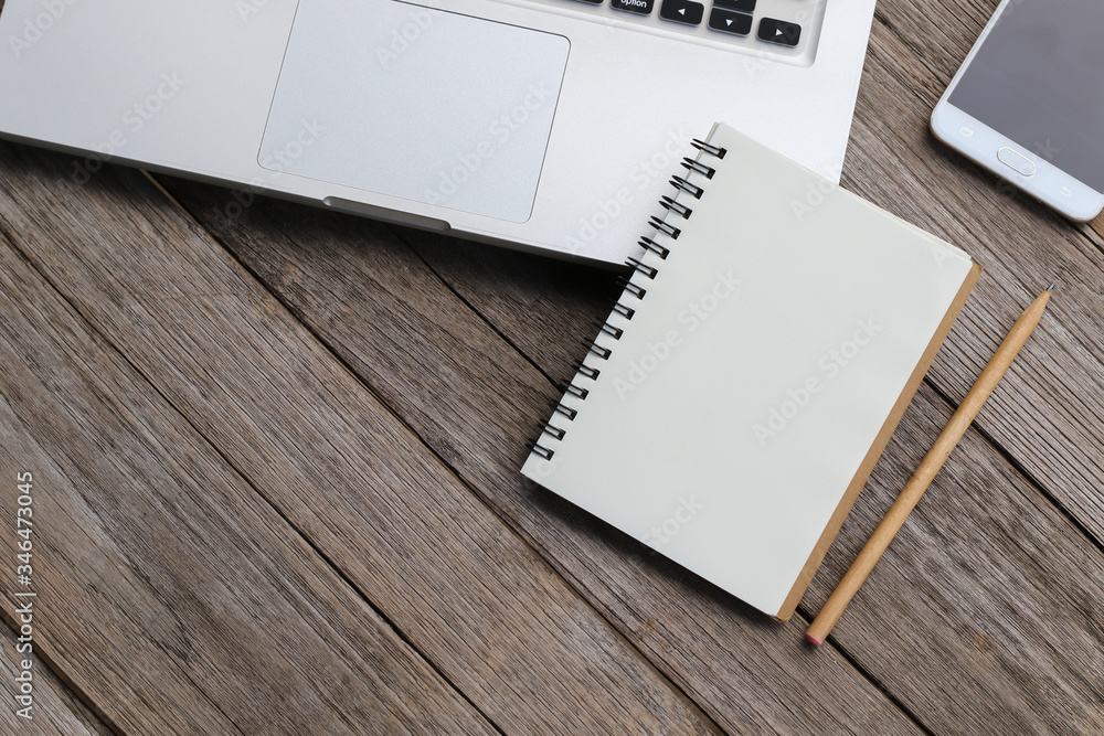 Blank notebook with laptop beside on wooden table Blank notebook with laptop beside on wooden table