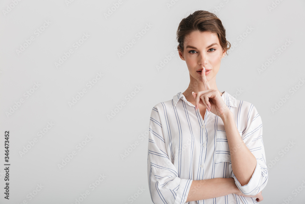 Image of serious nice woman showing silence gesture on camera Image of serious nice woman showing silence gesture on camera