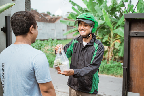 man ordering food online and receive the order at home delivered by courier