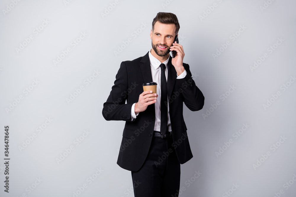 Portrait of positive agent man have work relax time hold take-out coffee beverage mug speak on cell phone colleagues family friends wear black pants blazer jacket isolated grey color background Portrait of positive agent man have work relax time hold take-out coffee beverage mug speak on cell phone colleagues family friends wear black pants blazer jacket isolated grey color background