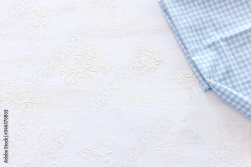 top view of checkered tablecloth with over white wooden background