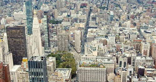 The famous Flatiron Building in New York City, and typical Manhattan buildings, parks, busy NY streets and skyscrapers.
