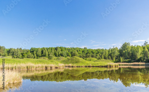 Green hills with reflection in the lake water