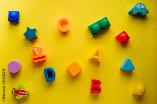 Top view on children s toys on a yellow background. Children's toys on the table. concept for advertising toys for children. Copy space children's toy. © Alexey