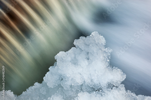 Winter landscape of the Orangeville Creek cascade framed with icicles and captured with motion blur, Michigan, USA