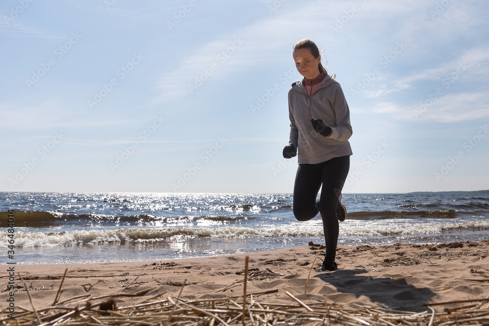 Girl runs on the beach, the silhouette of the athlete