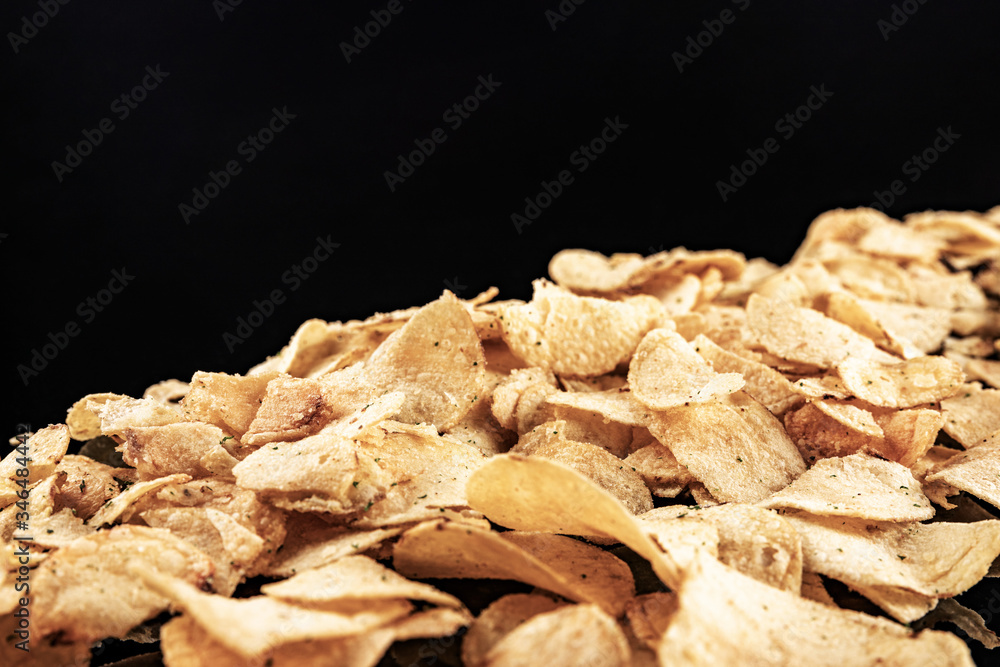 Potato chips on a black background, shallow depth of field, selective focus.