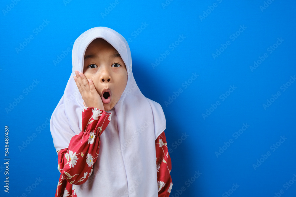 Portrait of funny young Asian Muslim girl with shocked expression Portrait of funny young Asian Muslim girl with shocked expression