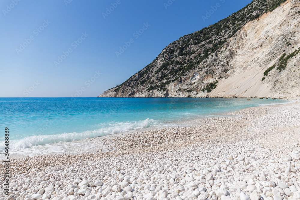 Fototapeta premium Beach with crystal clear turquoise water and white stones, waves at Myrtos beach, Kefalonia island, Greece