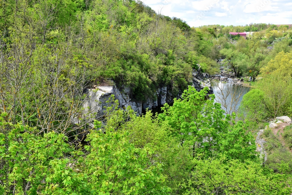 Fototapeta premium Beautiful peaceful landscape with green forest and mountain river near of the Buky canyon, Cherkasy region, Ukraine. Ukrainian landmarks. Domestic tourism. Buki canyon