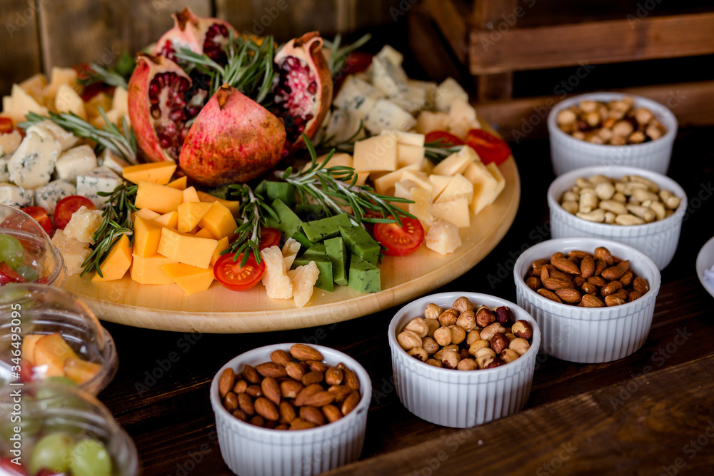 Close view of jamon rolls, cherry tomatoes, nuts and dried apricots served for festive occasion