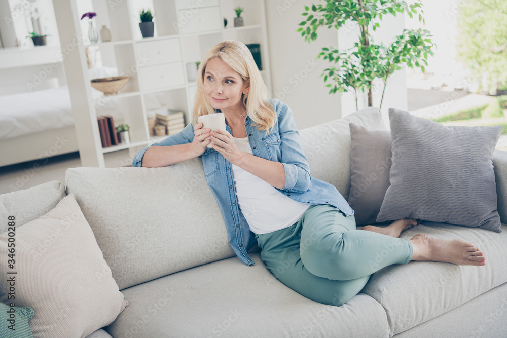 Photo of attractive aged mature homey domestic lady sitting comfy sofa couch drink coffee peaceful good mood relaxing enjoy staying home quarantine time weekend living room indoors Photo of attractive aged mature homey domestic lady sitting comfy sofa couch drink coffee peaceful good mood relaxing enjoy staying home quarantine time weekend living room indoors