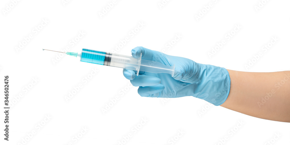 Female hand of a medic in a safe rubber glove of blue color in which a syringe with a liquid vaccine is blue, treatment of the disease on white background isolate. Female hand of a medic in a safe rubber glove of blue color in which a syringe with a liquid vaccine is blue, treatment of the disease on white background isolate.