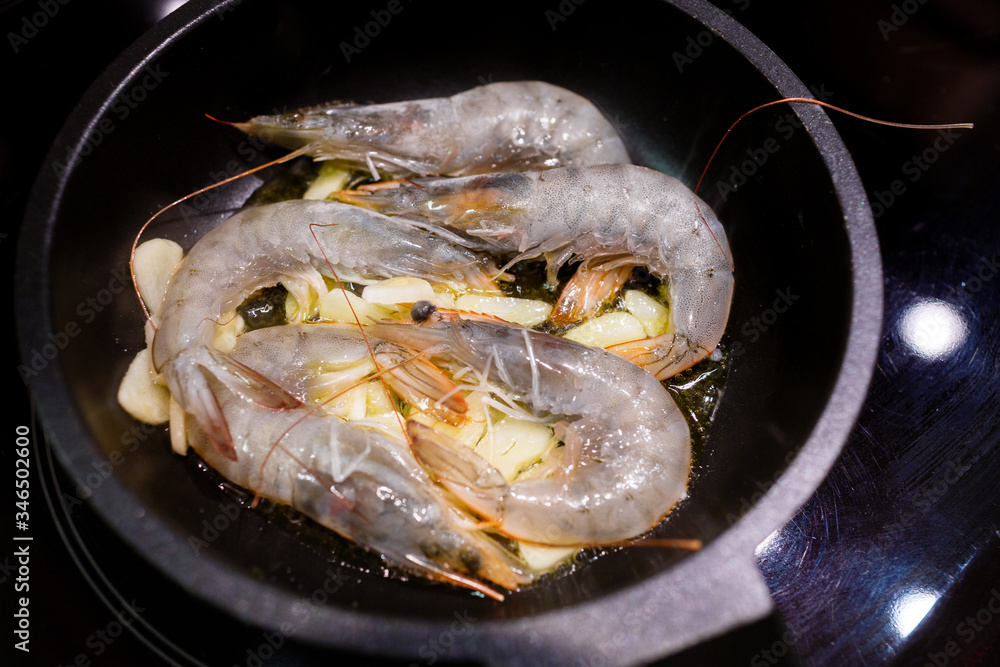 shrimp fried in olive oil with garlic in a small frying pan on an electric panel shrimp fried in olive oil with garlic in a small frying pan on an electric panel