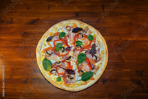 vegetarian Italian pizza with herbs and mushrooms and Basil on a wooden table