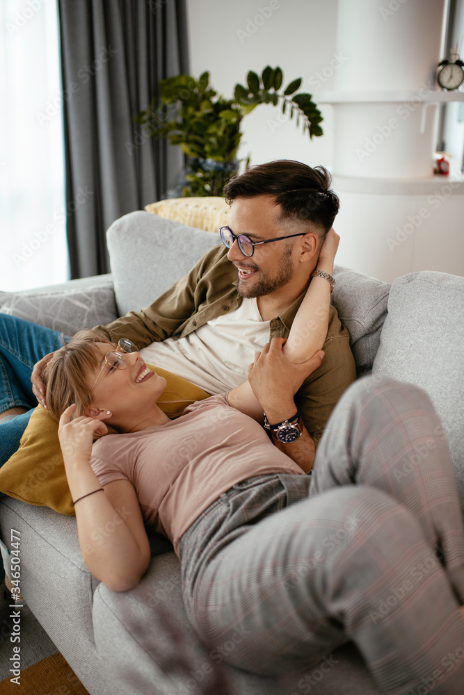 Young loving couple in sofa. Happy couple relaxing in living room.