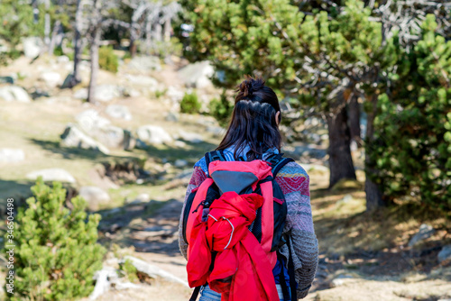 Rear view of a backpacker woman hiking