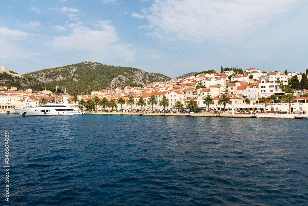 Hvar town on Hvar island, view from the sea on a sunny day in the summer blue sky. Clear adriactic water, the south mediterranean coast of Croatia in Europe. Beautiful landscape with mountains