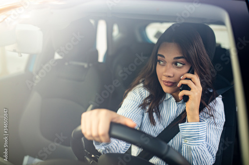 Businesswoman multitasking while driving, drinking coffee and talking on the phone. Distracted woman talking on her phone while driving. Woman Talking on Mobile while Driving