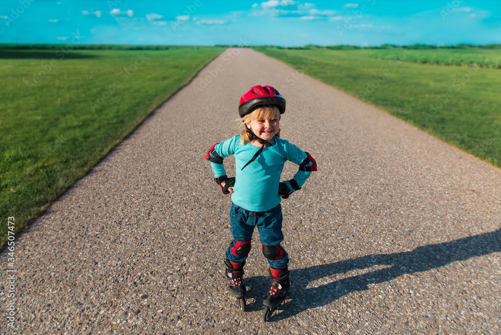 Fototapeta premium little girl on roller skates outdoors, kid exercise