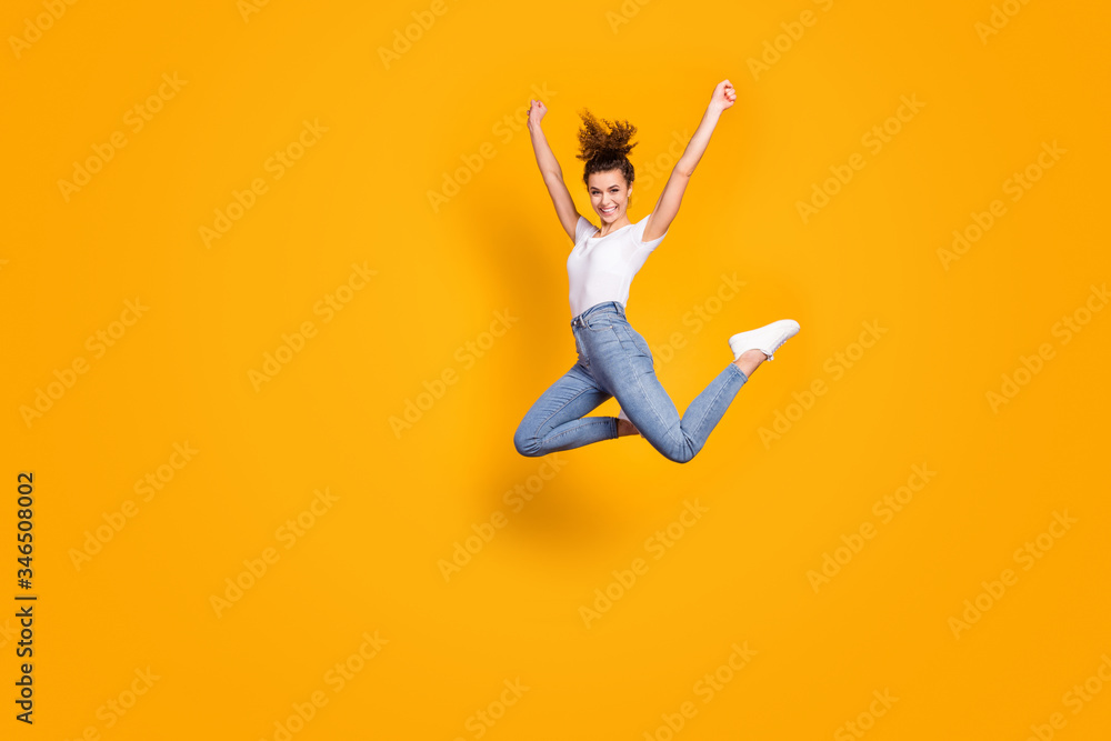 Full length profile photo of crazy lady jumping high up competitions marathon supporter cheering friends team wear white t-shirt jeans isolated yellow bright color background