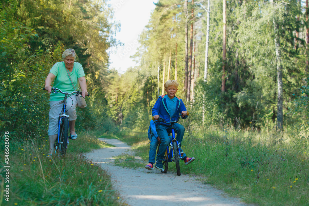 active senior grandmother with kids riding bikes in nature active senior grandmother with kids riding bikes in nature