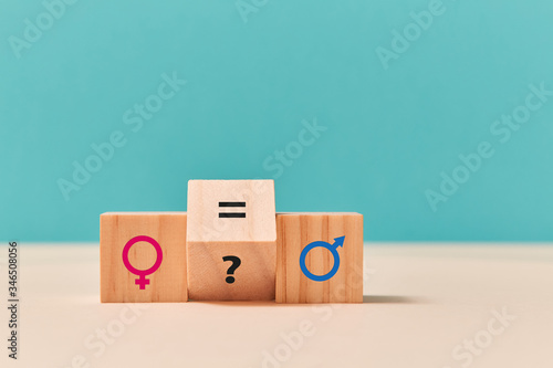 Gender, sexual equality. Human rights. Wooden cubes with feminism and masculism symbols, question mark and equal sign photo