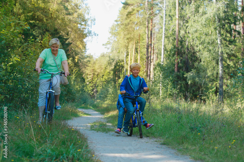 active senior grandmother with kids riding bikes in nature