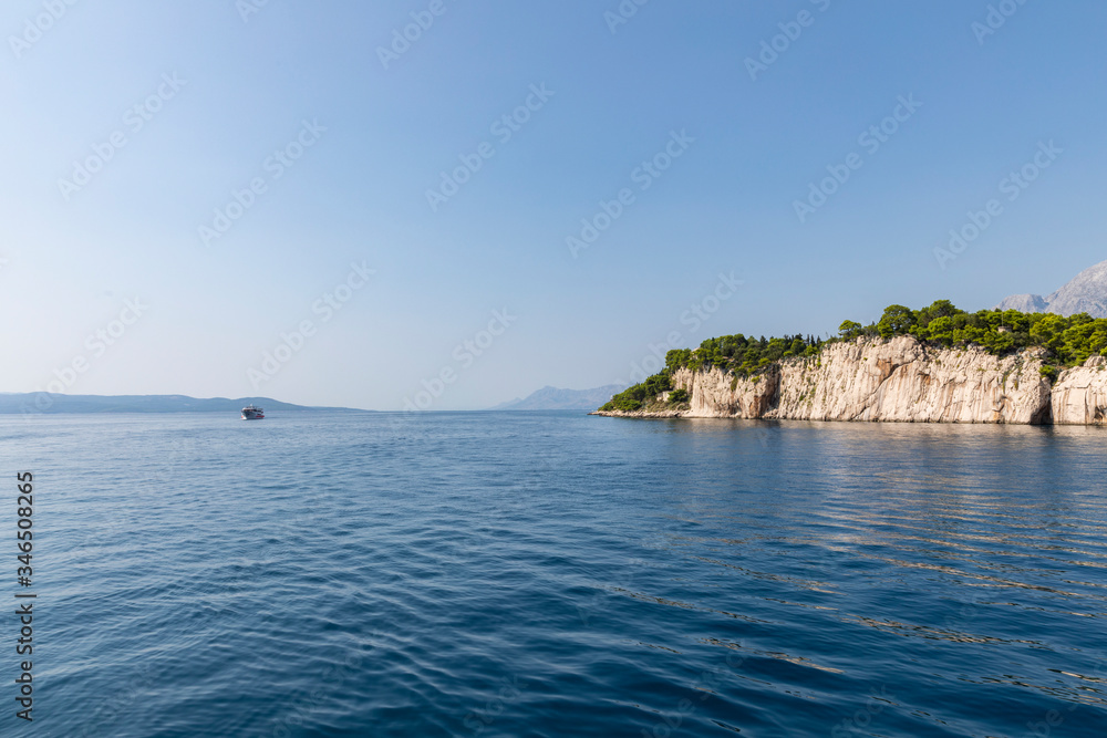 Makarska in Dalmatia, Croatia. View from the sea on a sunny day in the summer and a blue sky. A place famous for it’s beaches and the peninsula. Holiday destination, Mediterranean coast Makarska in Dalmatia, Croatia. View from the sea on a sunny day in the summer and a blue sky. A place famous for it’s beaches and the peninsula. Holiday destination, Mediterranean coast