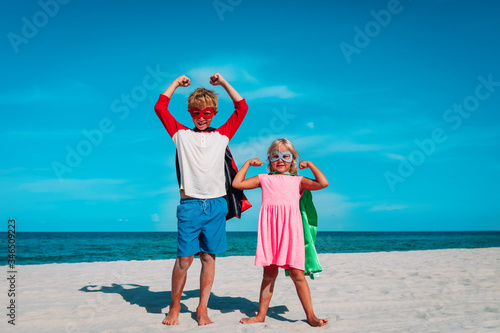 Bild auf Leinwand boy and girl play superheros on beach vacation