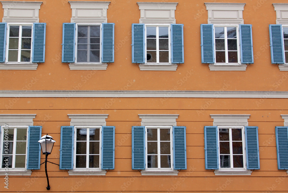 Many identical windows on orange building facade