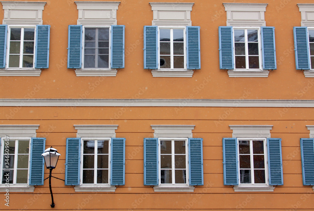 Many identical windows on orange building facade Many identical windows on orange building facade
