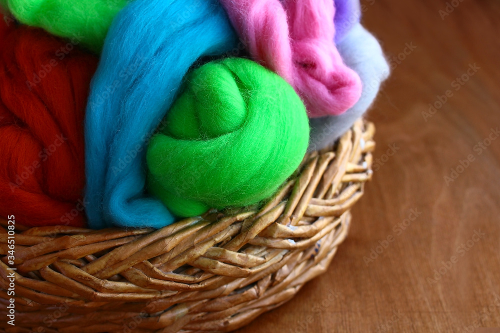 In a wicker basket, the natural eco-wool of sheep and alpaca skein, in multi-colored colors