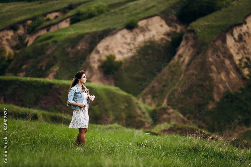 young beautiful girl runs on the green hills of the mountains young beautiful girl runs on the green hills of the mountains