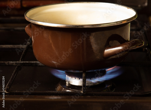 Brown pan of food stands above a gas burner