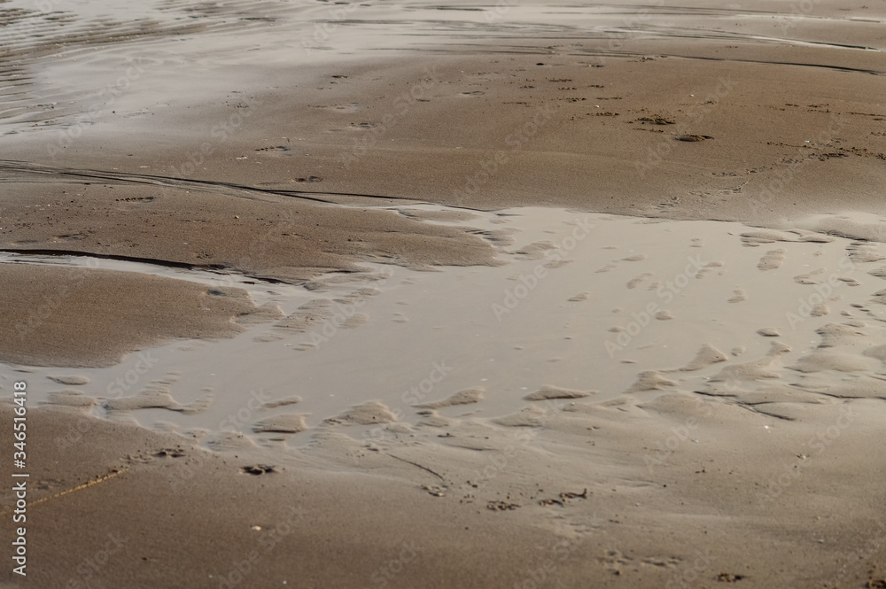 water and wet rippled sand at the beach at sunset background, Adriatic sea in Italy Italy water and wet rippled sand at the beach at sunset background, Adriatic sea in Italy Italy