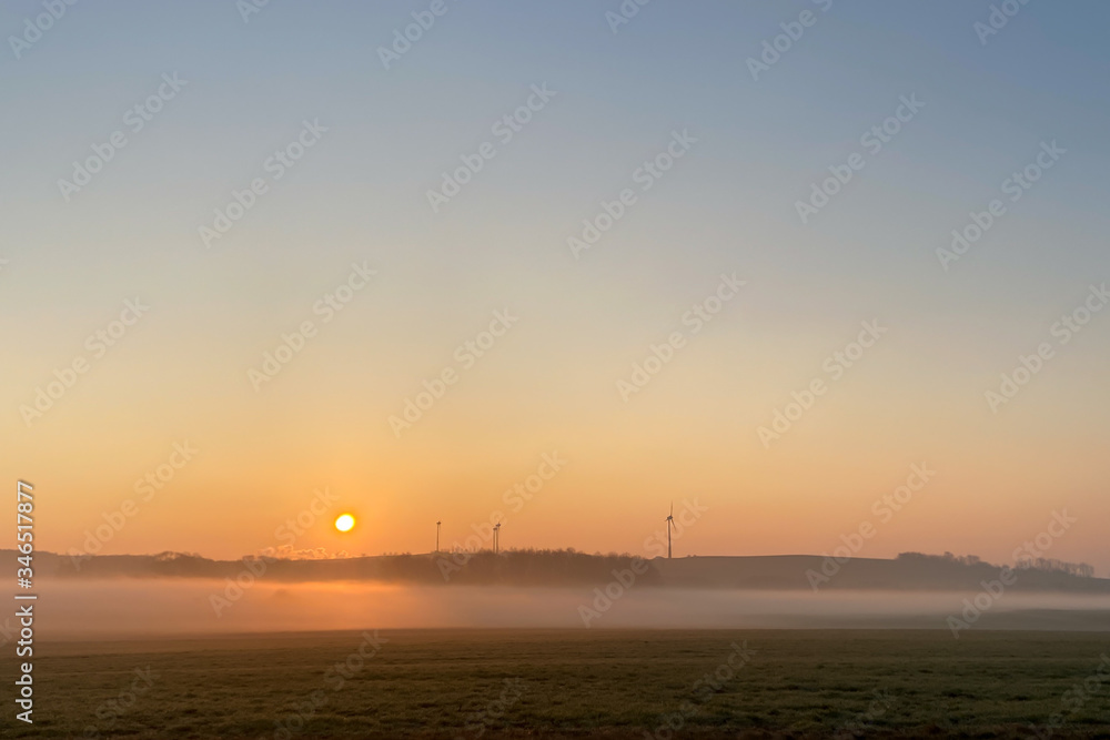 Fototapeta premium Sunrise over a meadow with ground fog