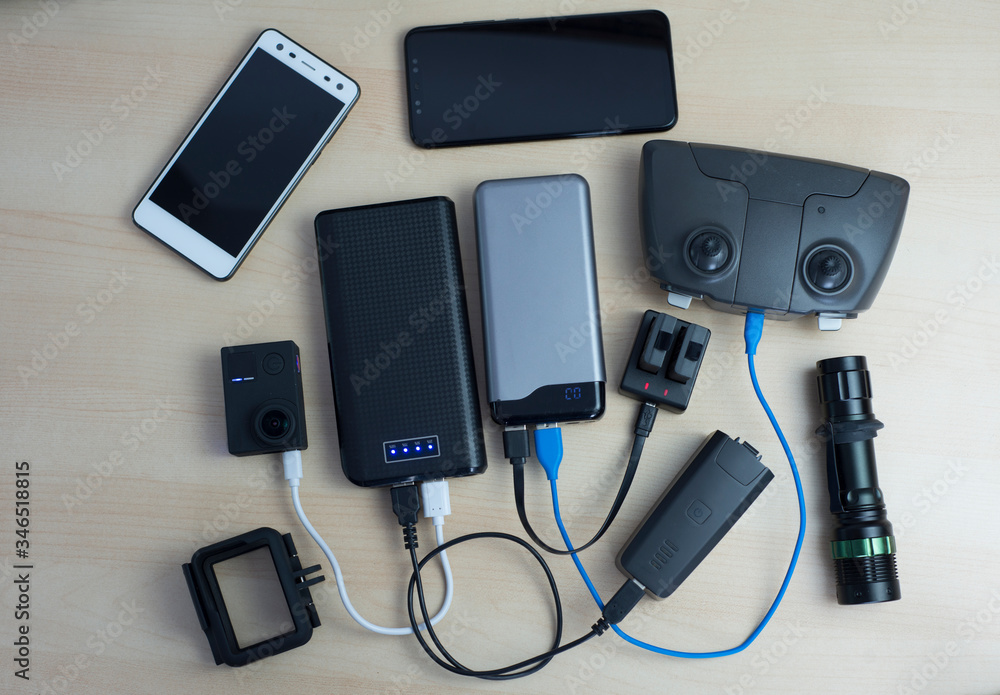 Fototapeta premium Powerbank-Ladegerät für Action-Kamera, Controller, Telefon, Akku, fotografiert über dem Tisch.