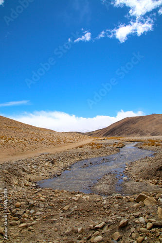 The magnificent scenery of the Everest Scenic Area, the brown hillside, the snowy mountains in the distance, the blue sky and white clouds, the road to the distance