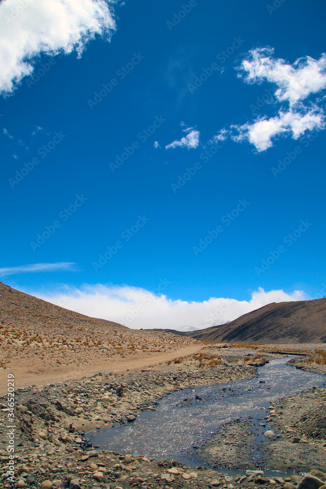 The magnificent scenery of the Everest Scenic Area, the brown hillside, the snowy mountains in the distance, the blue sky and white clouds, the road to the distance The magnificent scenery of the Everest Scenic Area, the brown hillside, the snowy mountains in the distance, the blue sky and white clouds, the road to the distance