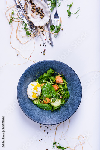 Salmon salad with spinach and poached egg in a bowl. Clean eating.  Mediterranean recipe. Top view, copy space.