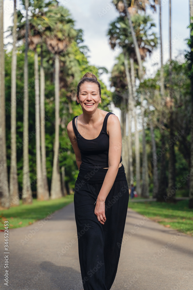 happy woman walks in botanical garden in Sri Lanka happy woman walks in botanical garden in Sri Lanka
