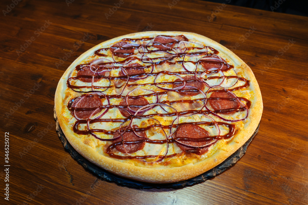 Italian pizza with sausage products on a wooden table Italian pizza with sausage products on a wooden table