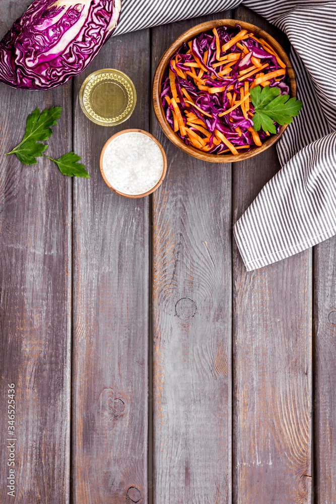 Healthy vegan salad with red cabbage on wooden kitchen table top view copy space